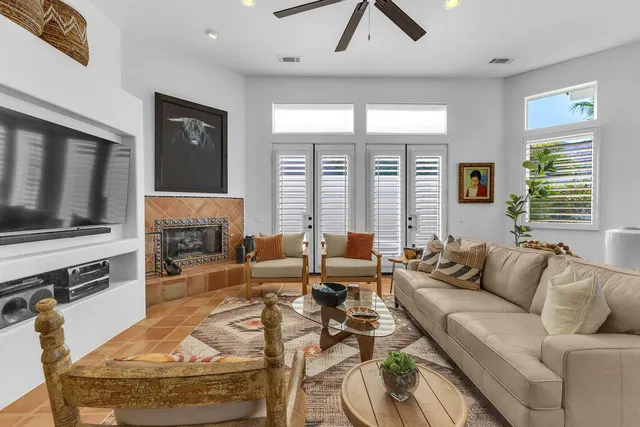 a living room with furniture kitchen view and large windows