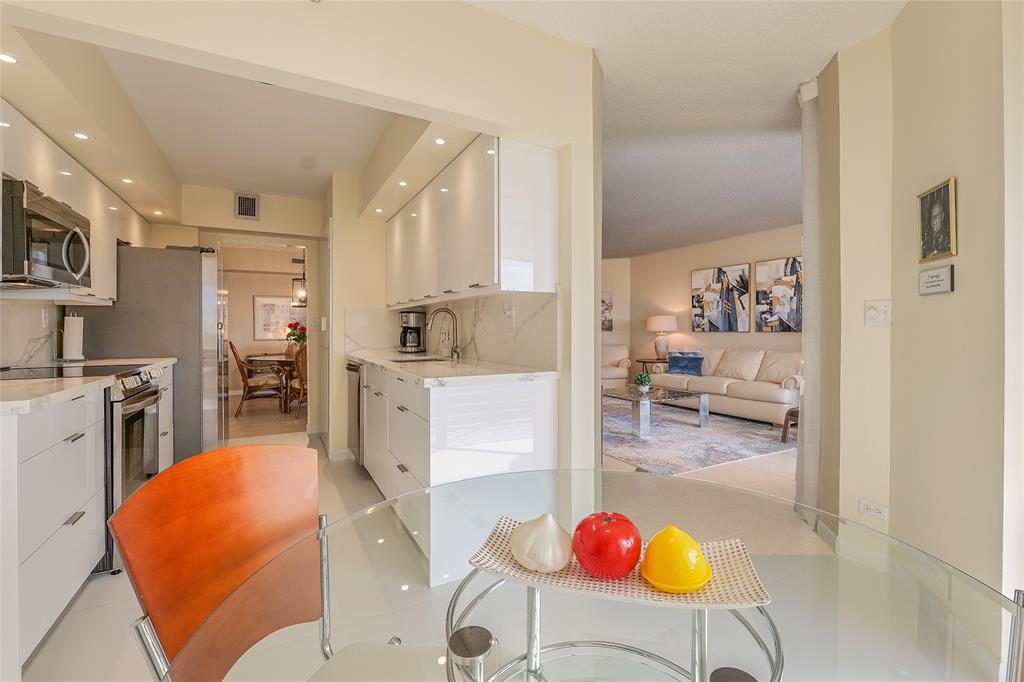 7200 Radice Court, Unit 705 Lauderhill, FL 33319 - Photo 16 of 54 a living room with stainless steel appliances furniture wooden floor and a kitchen view