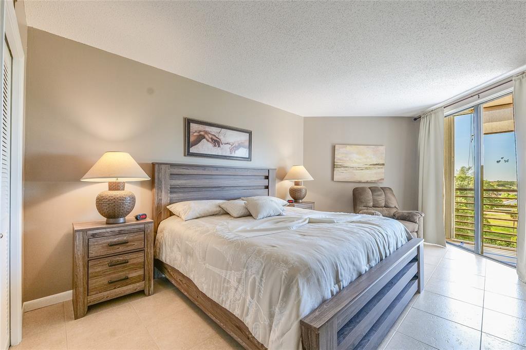 7200 Radice Court, Unit 705 Lauderhill, FL 33319 - Photo 23 of 54 a bedroom with a bed and a chandelier