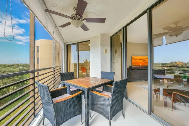 a dining room with furniture a floor to ceiling window and a ceiling fan