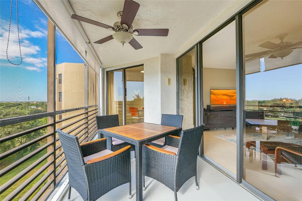 7200 Radice Court, Unit 705 Lauderhill, FL 33319 - Photo 3 of 54 a dining room with furniture a floor to ceiling window and a ceiling fan