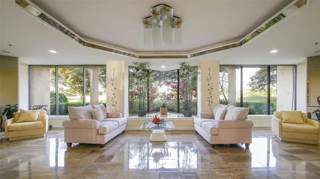 a view of a swimming pool with a lawn chairs and palm trees
