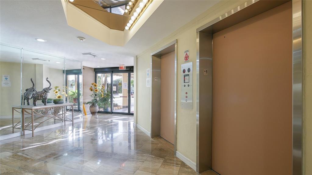 7200 Radice Court, Unit 705 Lauderhill, FL 33319 - Photo 51 of 54 a view of a hallway to a livingroom with furniture and floor to ceiling window