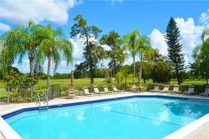 7200 Radice Court, Unit 705 Lauderhill, FL 33319 - Photo 52 of 54 a view of a swimming pool with a lawn chairs and palm trees