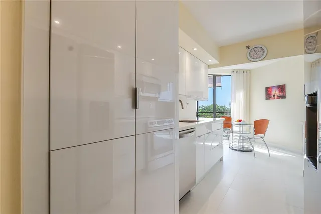 a kitchen with a white cabinets and chairs