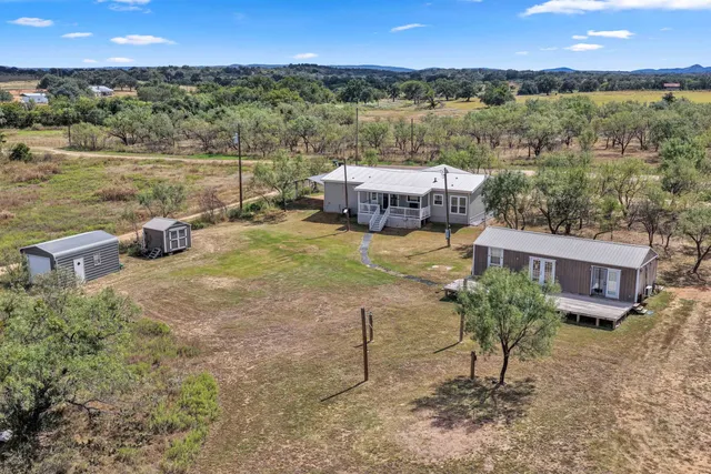 an aerial view of a house with a yard and lake view