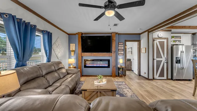 a living room with furniture a flat screen tv and a fireplace
