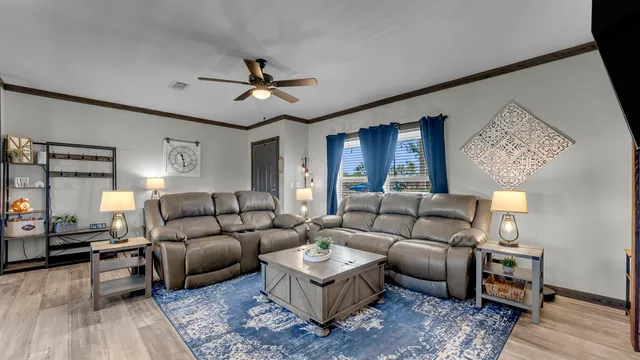 a living room with furniture and a ceiling fan