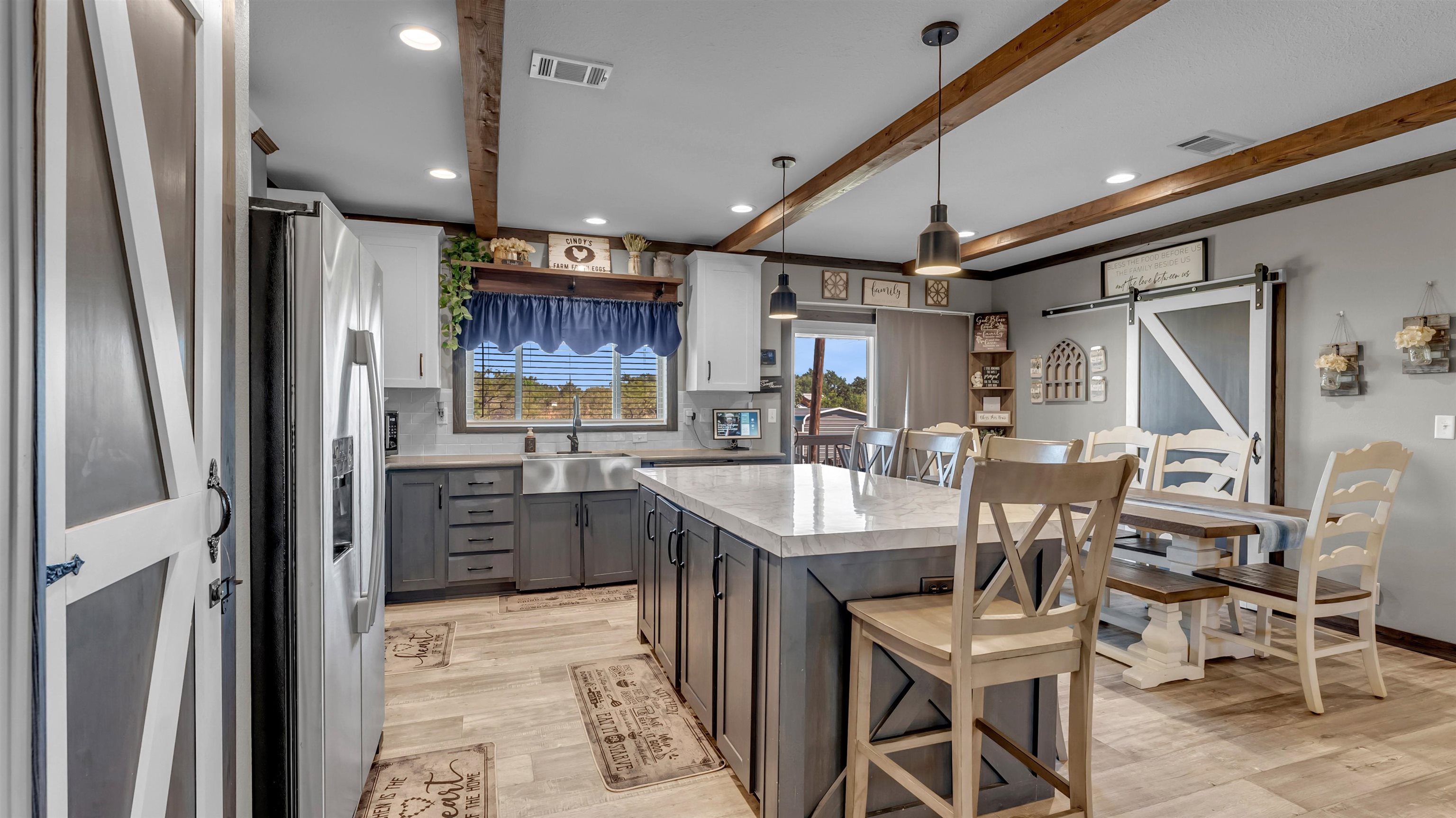 321 Flag Creek Ranch Circle Llano, TX 78643 - Photo 10 of 30 a kitchen with stainless steel appliances granite countertop a refrigerator a sink dishwasher a stove and a dining table with wooden floor