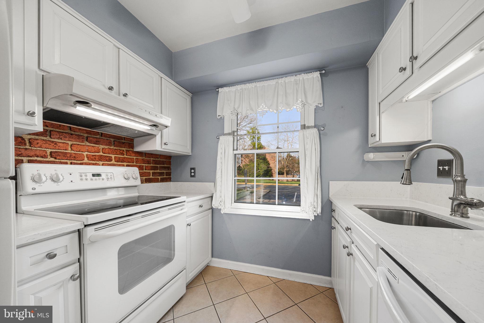 5845 Rexford Drive, Unit 721 Springfield, VA 22152 - Photo 10 of 32 a kitchen with white cabinets appliances and sink