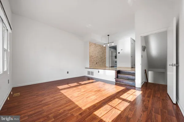 a spacious bedroom with a bed and wooden floor