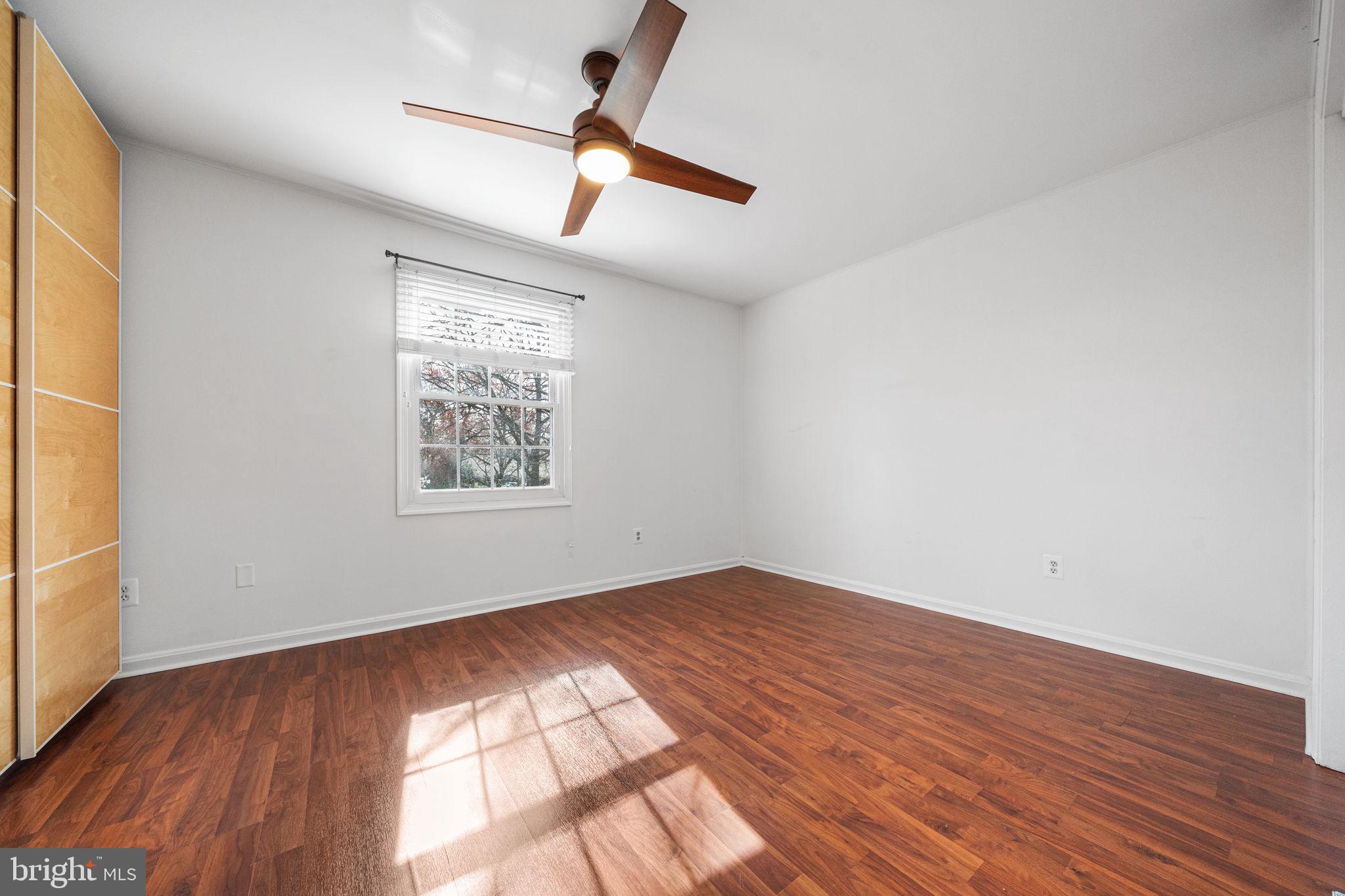 5845 Rexford Drive, Unit 721 Springfield, VA 22152 - Photo 15 of 32 an empty room with wooden floor fan and windows