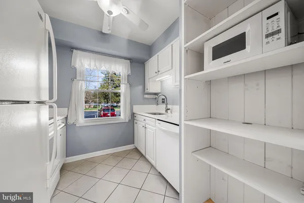 a kitchen with white cabinets and white appliances