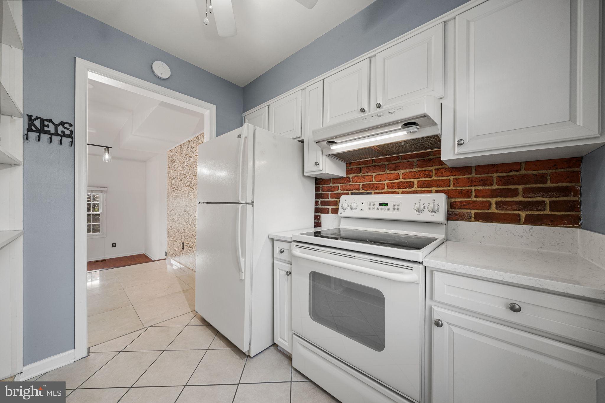 5845 Rexford Drive, Unit 721 Springfield, VA 22152 - Photo 7 of 32 a kitchen with white cabinets and white appliances