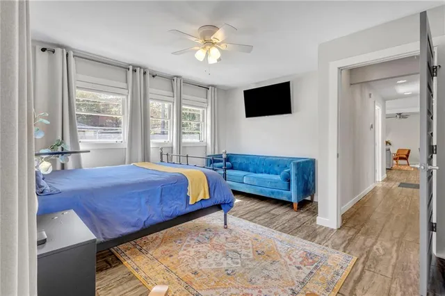 a living room with a bed furniture and a flat screen tv