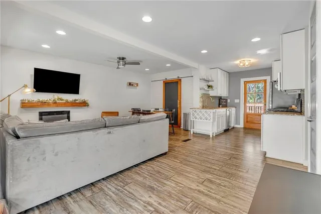 a large white kitchen with cabinets and flat screen tv
