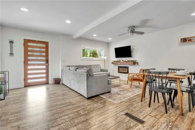 a living room with furniture a flat screen tv and a fireplace