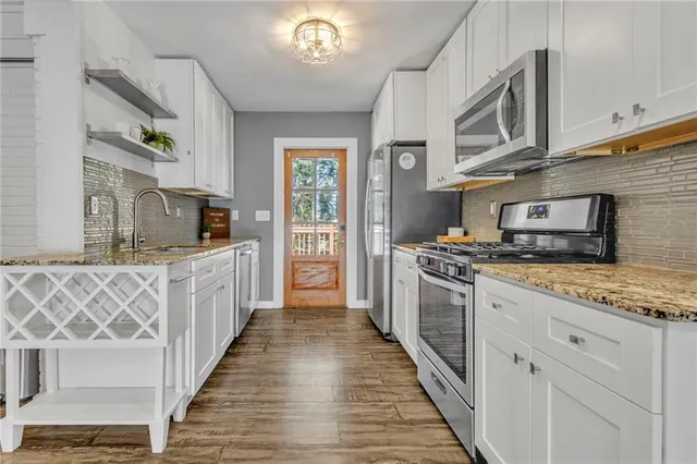 a kitchen with stainless steel appliances granite countertop a stove and a sink