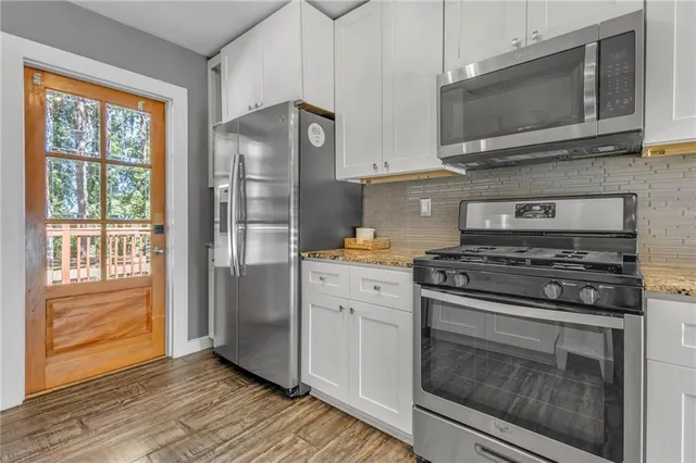 a kitchen with stainless steel appliances granite countertop a stove microwave and refrigerator