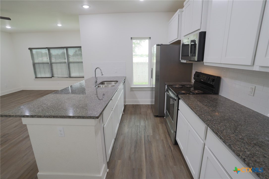 1838-1850 Royal Loop Belton, TX 76513 - Photo 4 of 9 a kitchen with granite countertop stainless steel appliances a sink stove and refrigerator