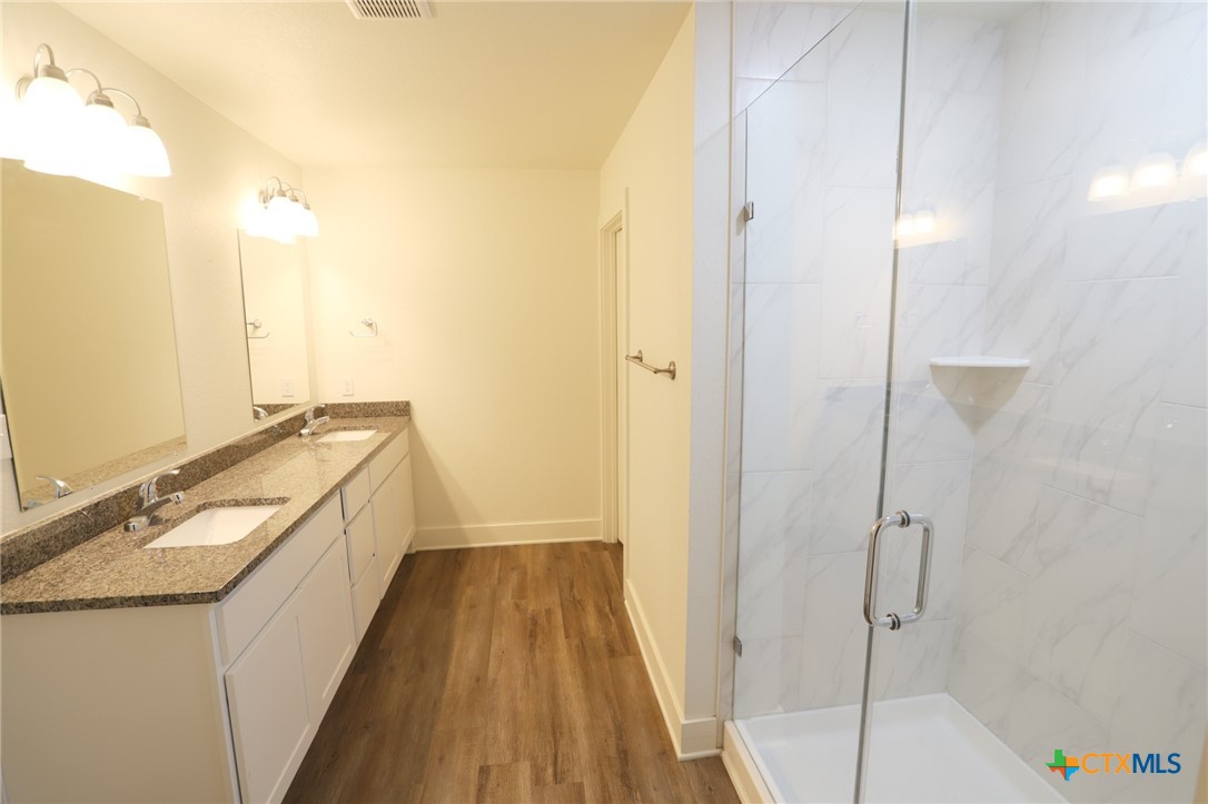 1838-1850 Royal Loop Belton, TX 76513 - Photo 6 of 9 a bathroom with a granite countertop sink a mirror and a shower