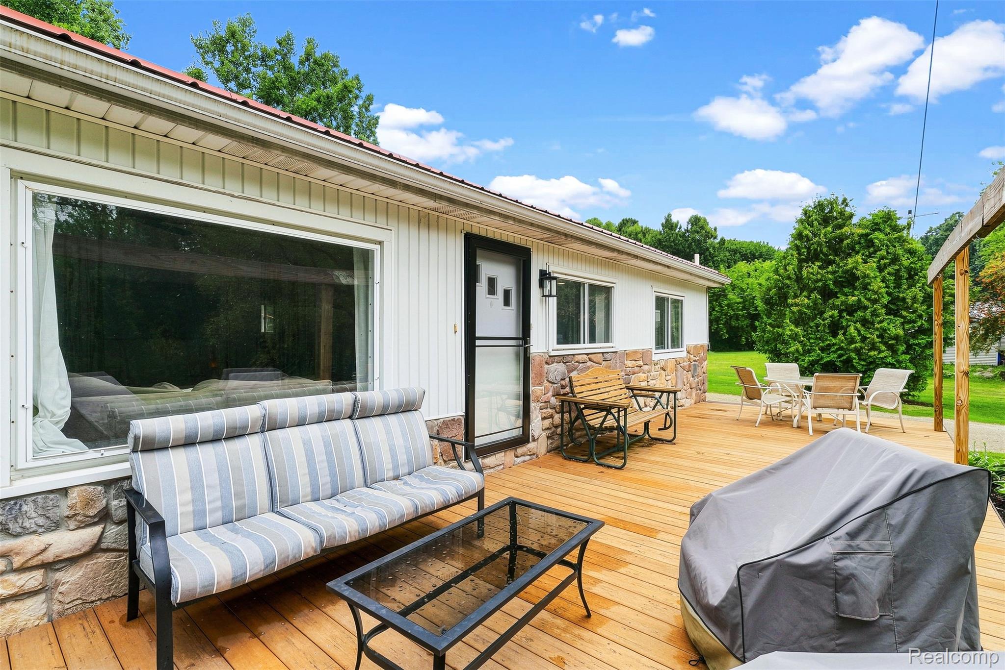 3319 Valentine Road Lapeer, MI 48446 - Photo 4 of 39 Expansive wood-finish deck with stone-veneer exterior accents