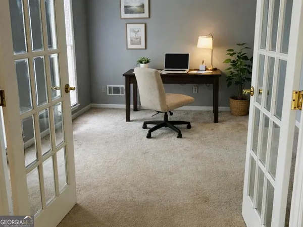 a view of a workspace with furniture and a window