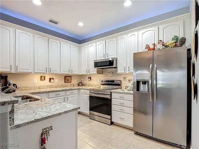 a kitchen with cabinets stainless steel appliances and a counter space