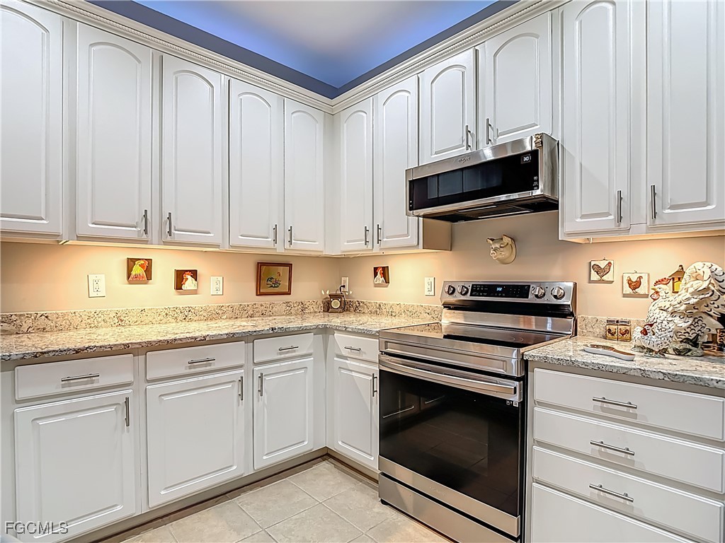 3630 Rue Alec Loop, Unit 1 North Fort Myers, FL 33917 - Photo 14 of 50 a kitchen with granite countertop white cabinets and stainless steel appliances