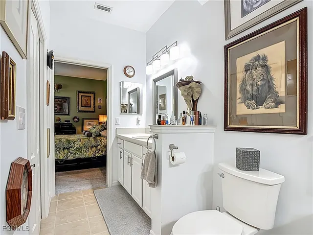 a en suite bathroom with a toilet a sink and a mirror