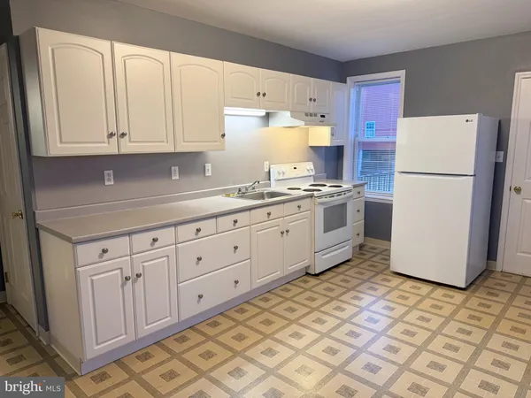 a kitchen with a white cabinets and white appliances