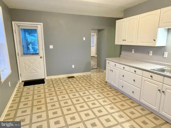 a view of a kitchen with white cabinets