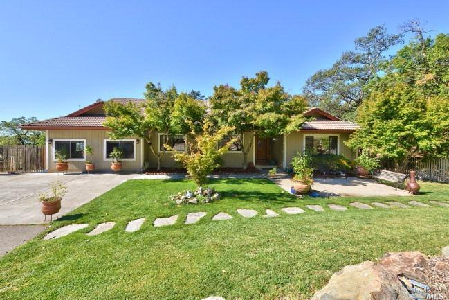 a view of a house with a yard and sitting area