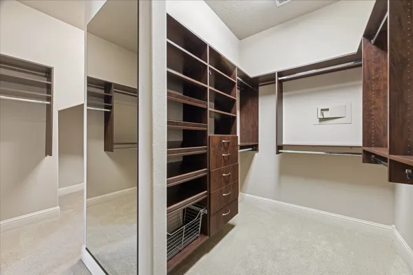 a view of walk in closet with empty racks