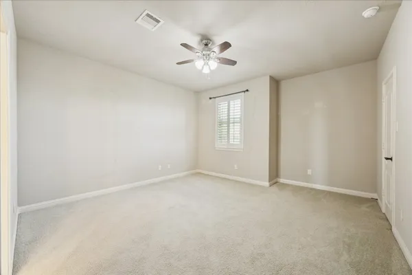 an empty room with windows and fan