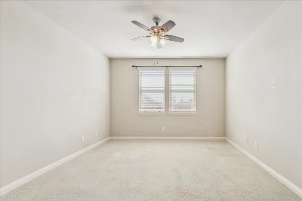 an empty room with a window and a ceiling fan