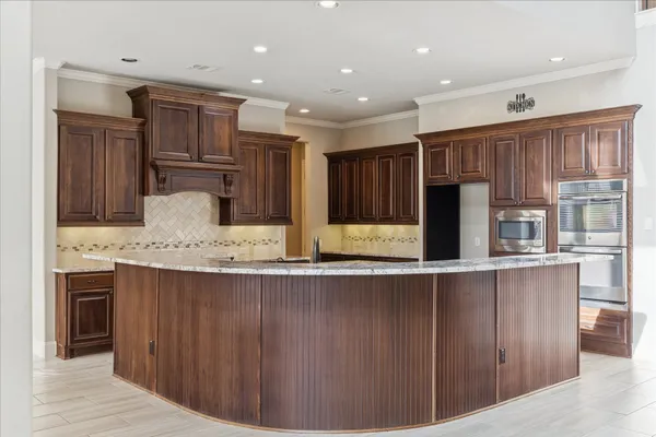 a kitchen with kitchen island granite countertop a stove and a sink