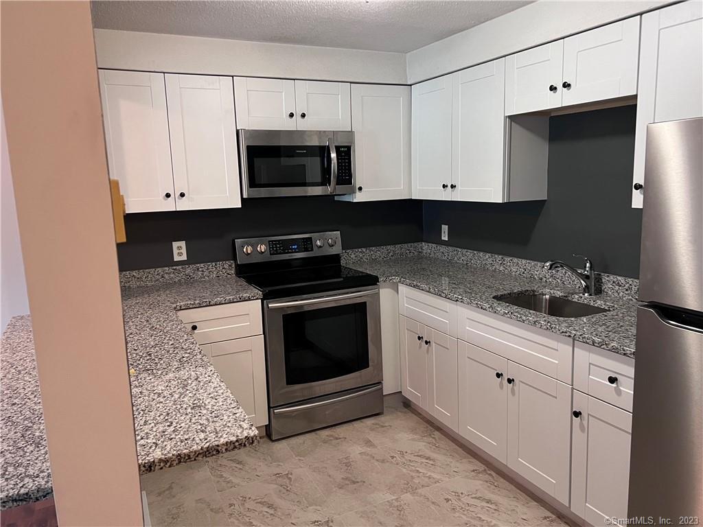 787 North Colony Road, Unit 11 Meriden, CT 06450 - Photo 1 of 1 a kitchen with granite countertop white cabinets and stainless steel appliances