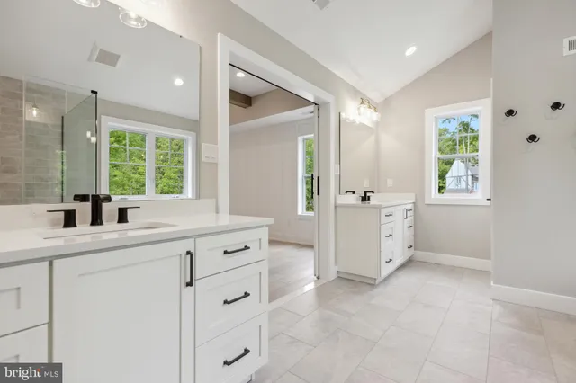a bathroom with a granite countertop sink mirror and window
