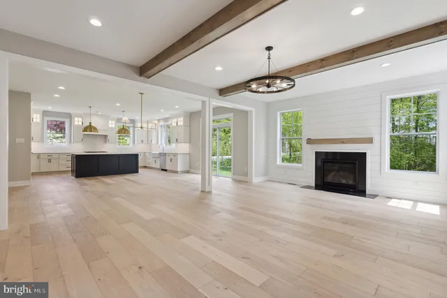 a view of an empty room with a fireplace and window