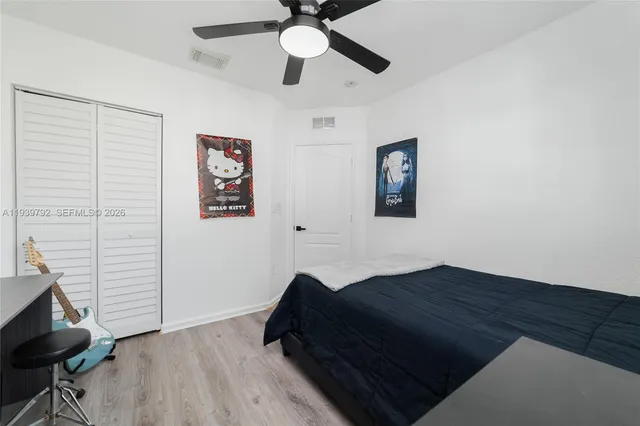 a bedroom with a bed and wooden floor