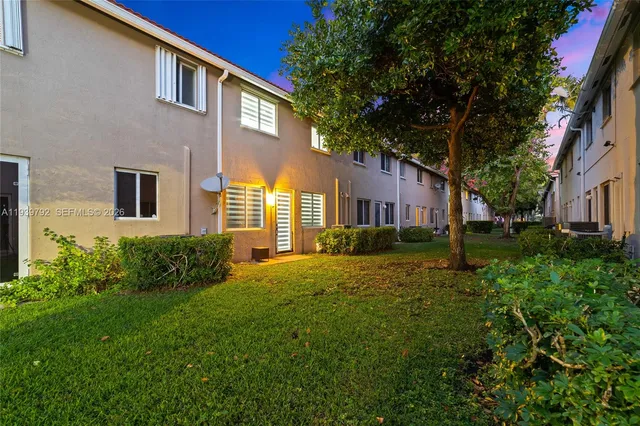 a front view of a house with a yard and trees