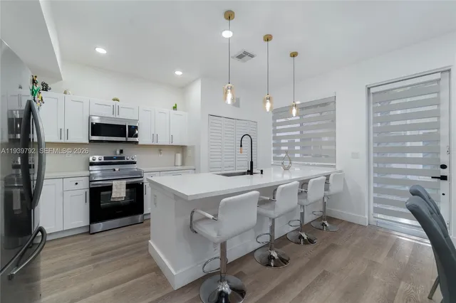 a kitchen with a stove a sink and a refrigerator