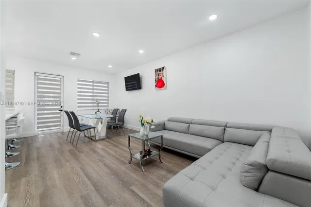 a living room with furniture and a wooden floor