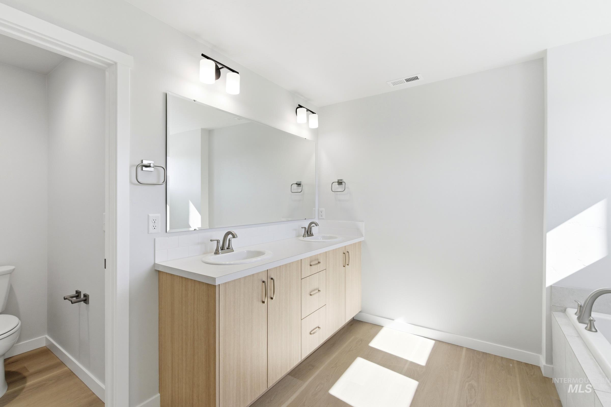 13677 Redway Court Caldwell, ID 83607 - Photo 32 of 35 Double vanity with wood-finish cabinetry, white countertops, and dual undermount sinks