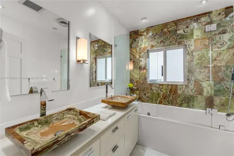 a bathroom with a tub sink and mirror
