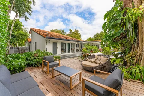 a view of a patio with couches table and chairs and potted plants