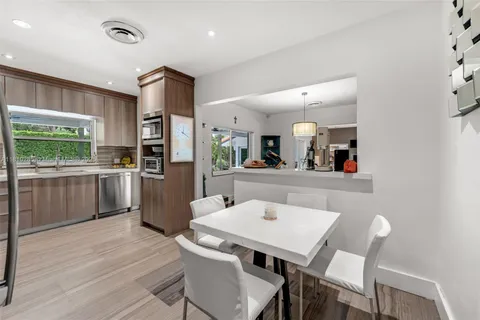 a kitchen with a table chairs microwave and refrigerator