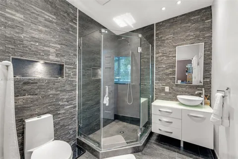 a bathroom with a toilet a sink and glass door
