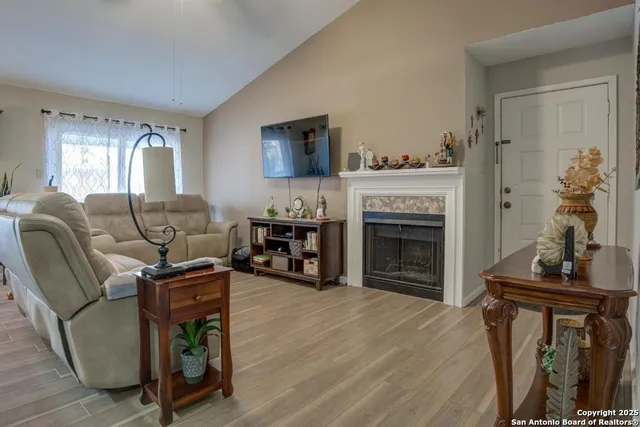 a living room with furniture a fireplace and a flat screen tv